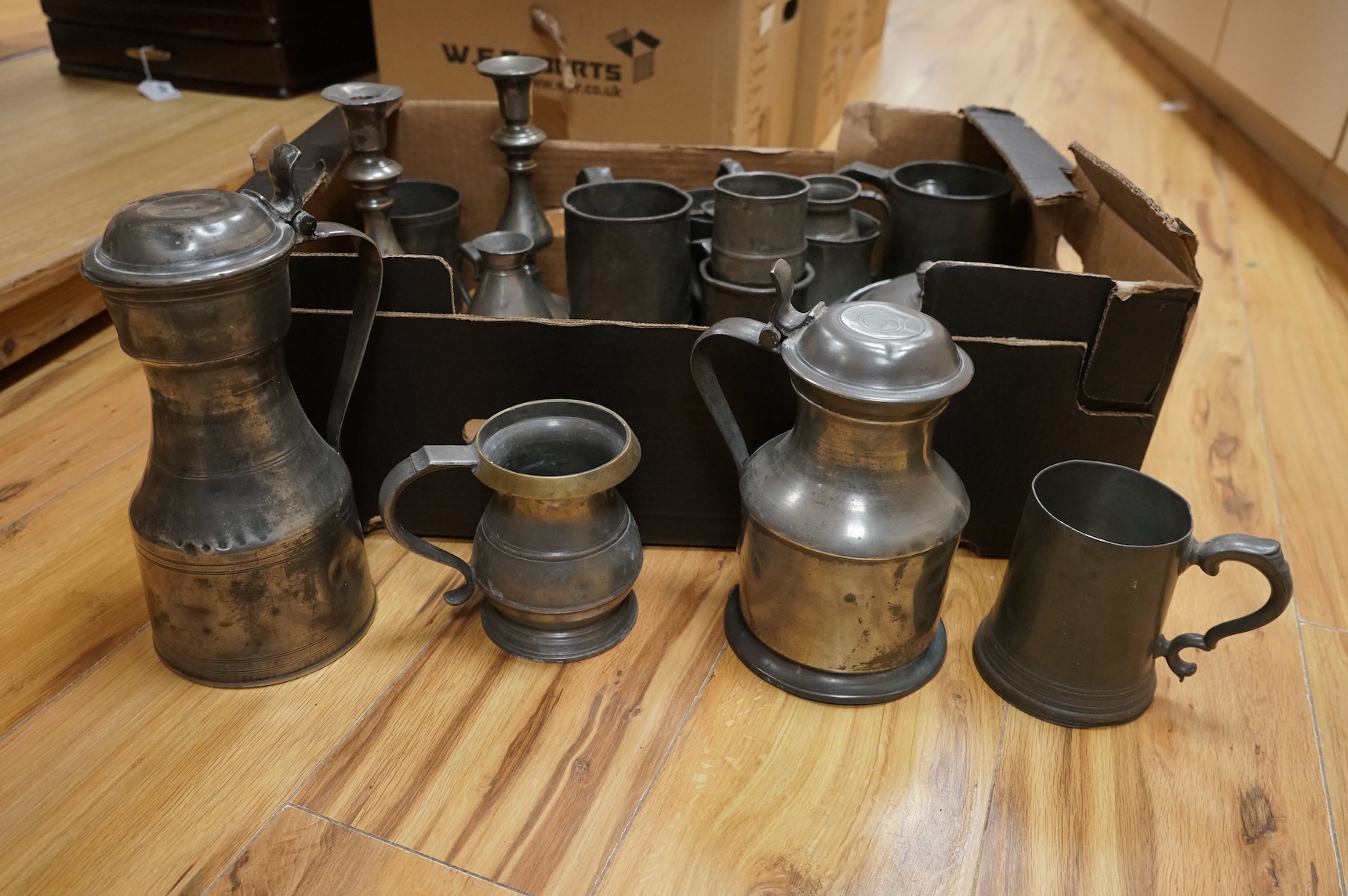 A quantity of pewter to include tankards, dishes and a pair of candlesticks